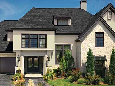 Front view of a beige mid-class home with black GAF shingles on its roof